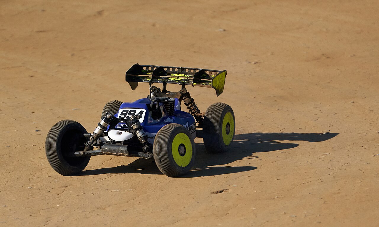 A radio-controlled buggy on dirt.