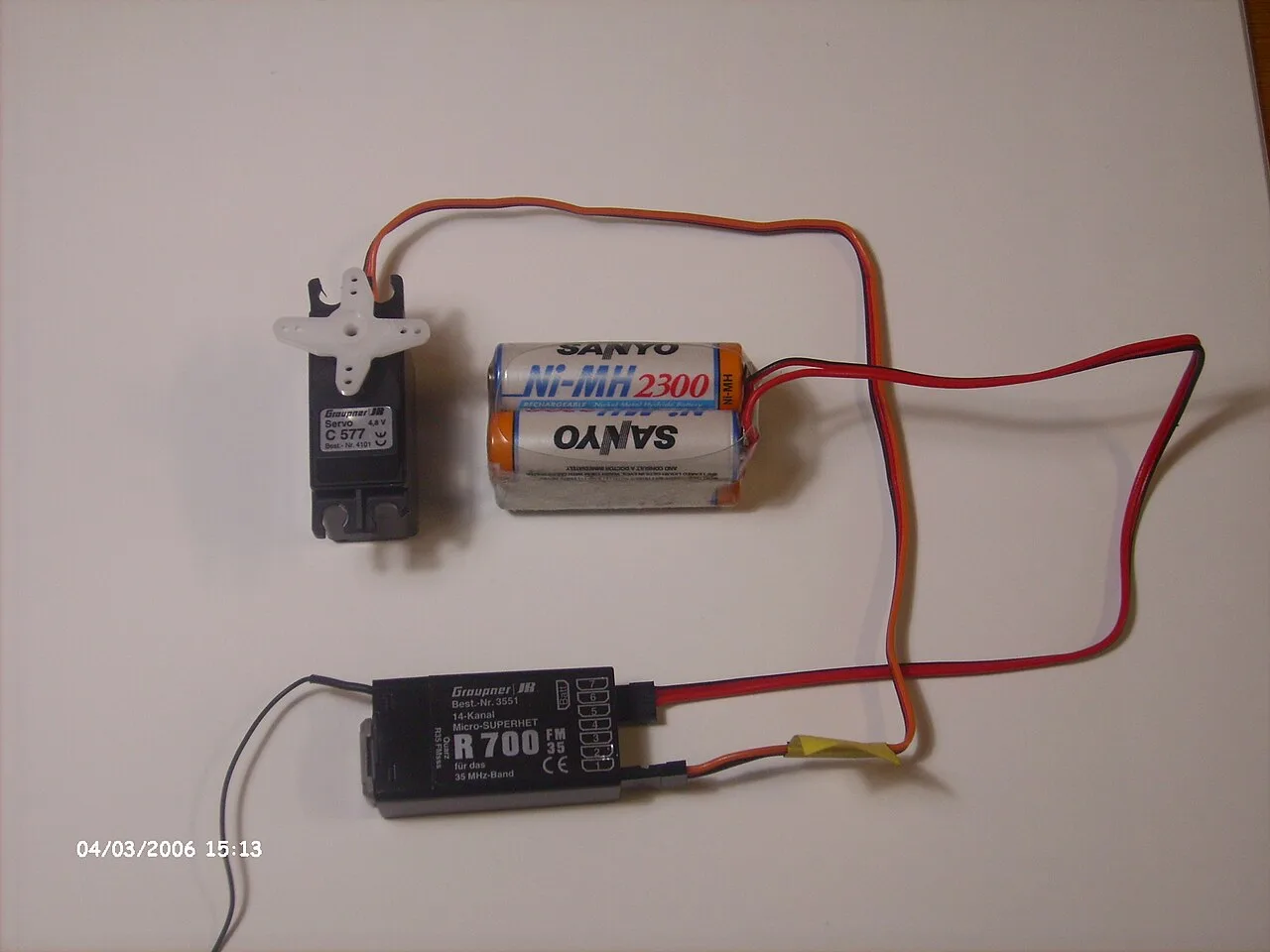 An older 35 MHz receiver, servo and receiver battery arranged together.