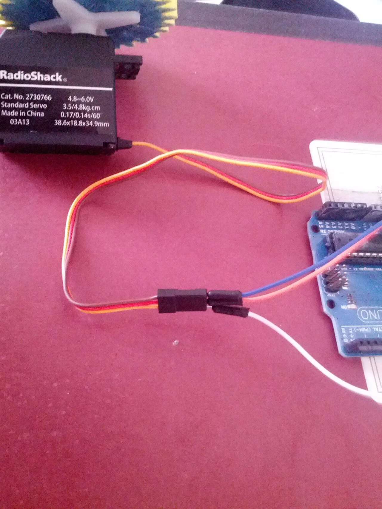 A RadioShack servo connected to an Arduino board on a desk.