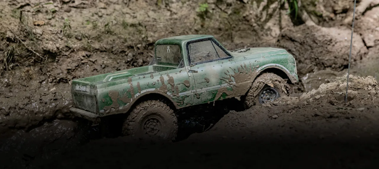 An RC scale vehicle driving outdoors at Axialfest Badlands 2022.