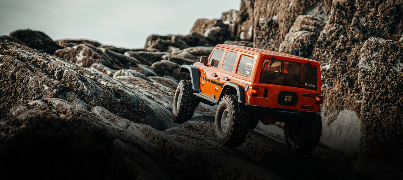 An RC scale vehicle on a rocky outdoor trail in Axial’s Wales adventure coverage.